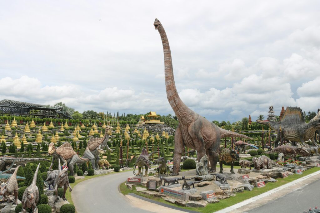 Explore impressive dinosaur sculptures at Nong Nooch Tropical Botanical Garden in Thailand.
