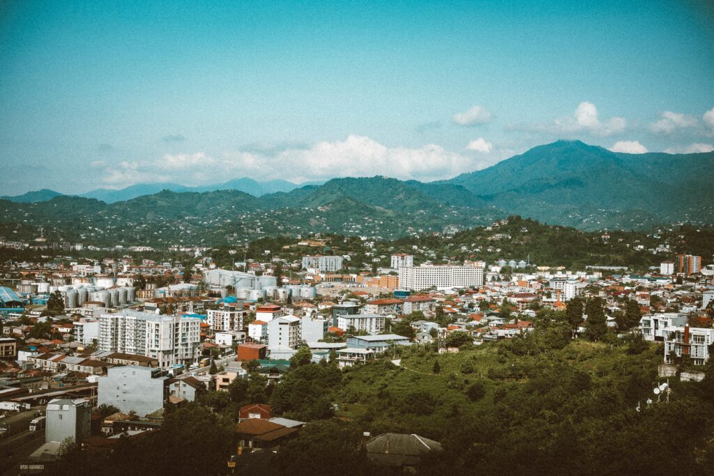 Stunning aerial view of Batumi, Georgia, with lush mountains in the background, capturing the city's vibrant architecture.